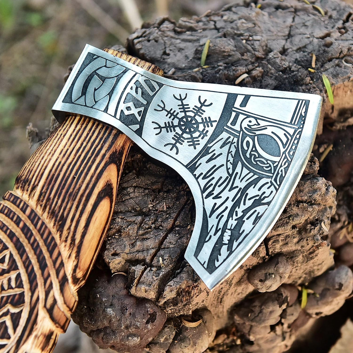 Decorative axe with wooden handle and patterned blade on a wooden surface
