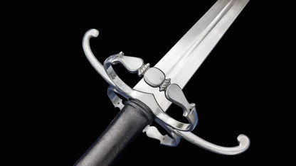 A close-up of a medieval-style sword with a polished silver-colored steel blade, guard, and pommel, and a black grip