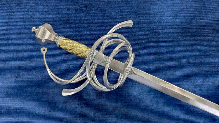 A medieval-style sword with a silver-colored steel guard and pommel, a gold-wrapped grip, and a straight blade, displayed diagonally on a textured blue velvet background.