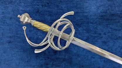 A medieval-style sword with a silver-colored steel guard and pommel, a gold-wrapped grip, and a straight blade, displayed diagonally on a textured blue velvet background.
