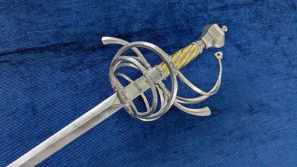 A medieval-style sword with a silver-colored steel blade, a silver wire guard, and a gold-wrapped hilt, displayed diagonally on a textured blue fabric background.