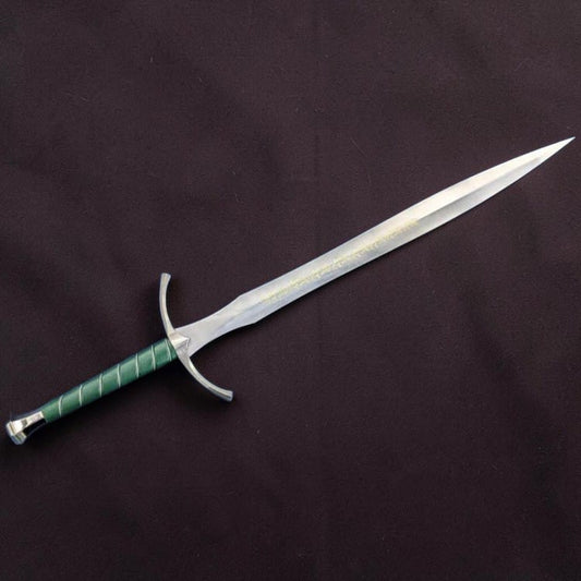 A fantasy-style sword with a silver blade, curved silver crossguard, and a green wrapped hilt, displayed diagonally on a dark textured fabric background.