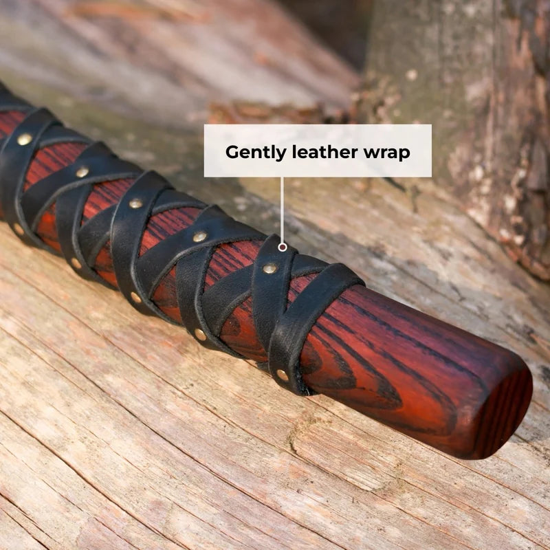 Wooden stick with black leather wrap on a wooden surface
