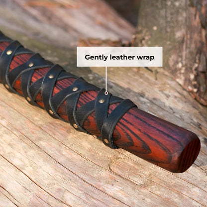 Wooden stick with black leather wrap on a wooden surface