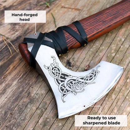 Hand-forged axe with decorative blade on a wooden surface