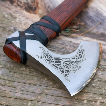Decorative axe with engraved design on a wooden surface