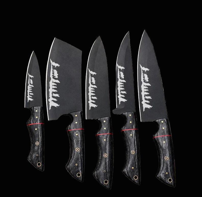 Four Japanese-style kitchen knives with dark gray blades featuring white kanji characters and black handles with gold and red accents, arranged on a newspaper background.