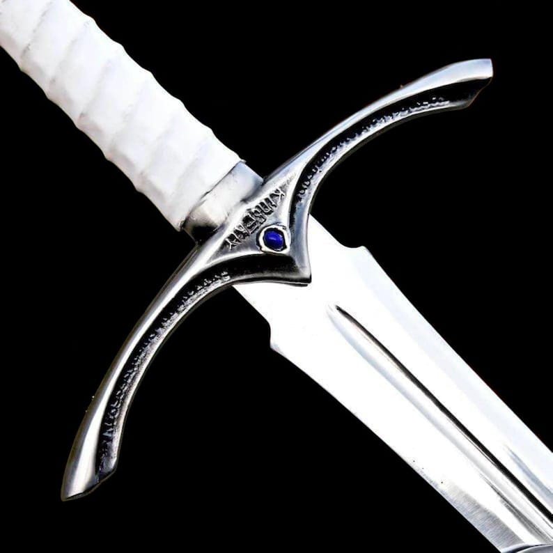 Close up image of the medieval knight longsword crossguard and polished high steel blade with decorative steel detailing