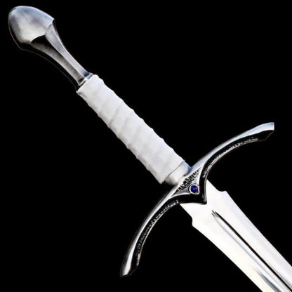 Close up image of the handmade medieval knight longsword handle with white leather grip, decorative steel guard, and polished pommel