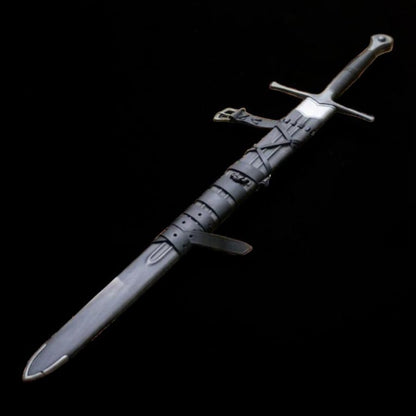 Close view of medieval longsword with dark wrapped handle, straight crossguard, and leather scabbard