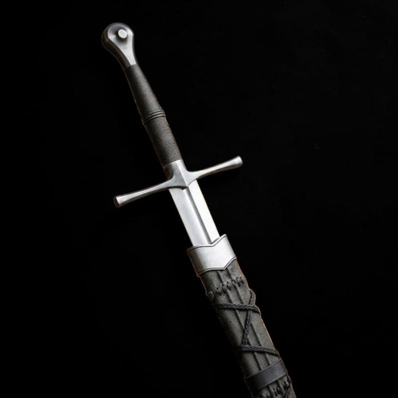 Medieval longsword with dark leather-wrapped handle and matching scabbard shown against a black background