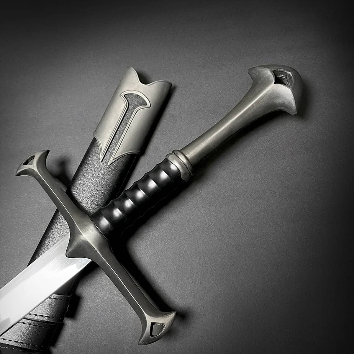 Close-up of a medieval sword handle and decorative crossguard with detailed metal craftsmanship