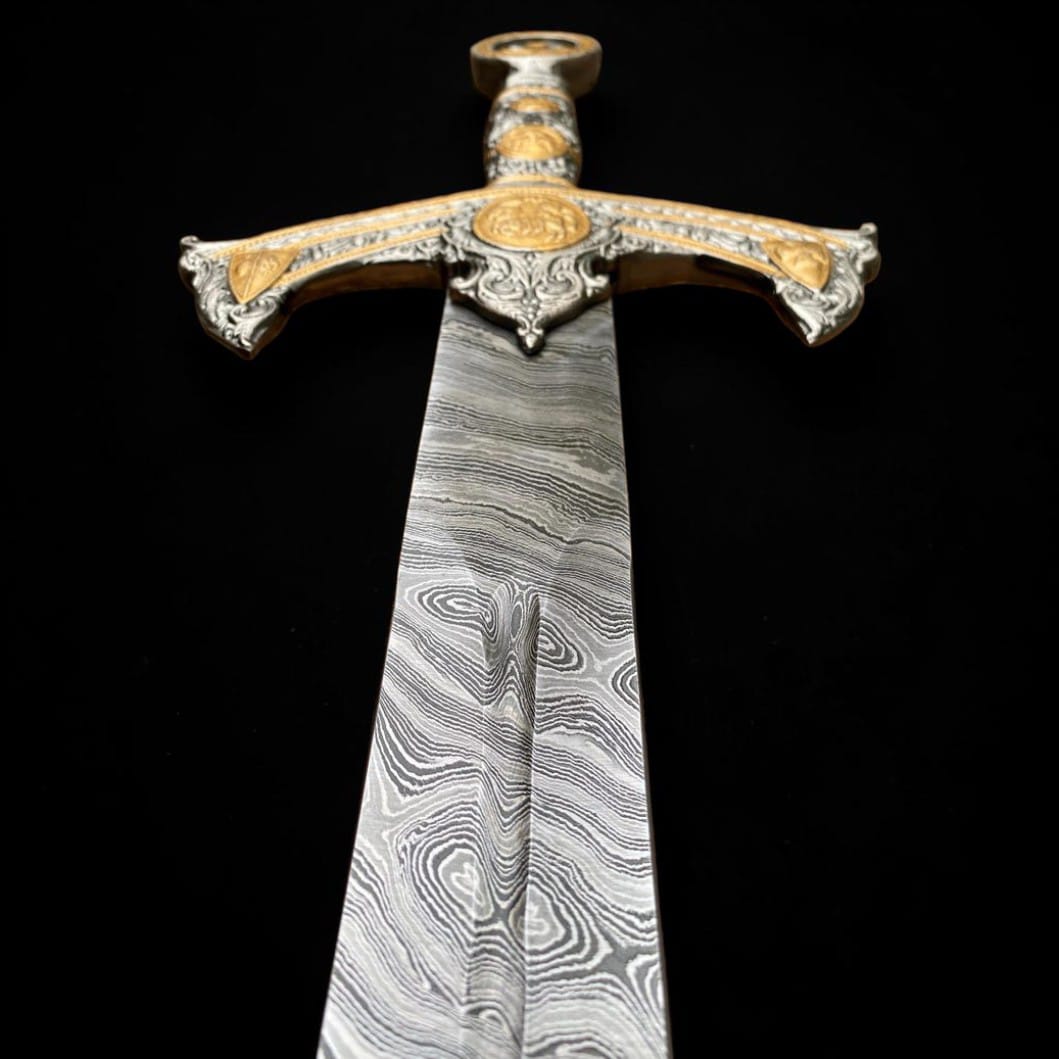 Close-up view of a handmade Damascus steel Templar sword blade showing detailed layered steel pattern and ornate crossguard.